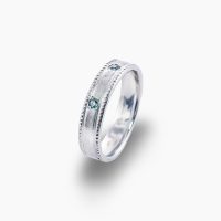 昼の太陽光の下では穏やかな青緑に、夜の灯りの下では神秘的な赤紫へ―光によって表情を変える3石のアレキサンドライトを、贅沢にあしらい、プラチナのマットな質感と、側面に施された繊細なミル打ち装飾が、アンティークの趣と気品を添えるリング　03